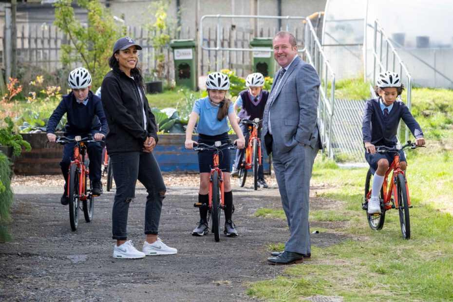 Erwachsene und Kinder mit Fahrrädern vor einem Gebäude