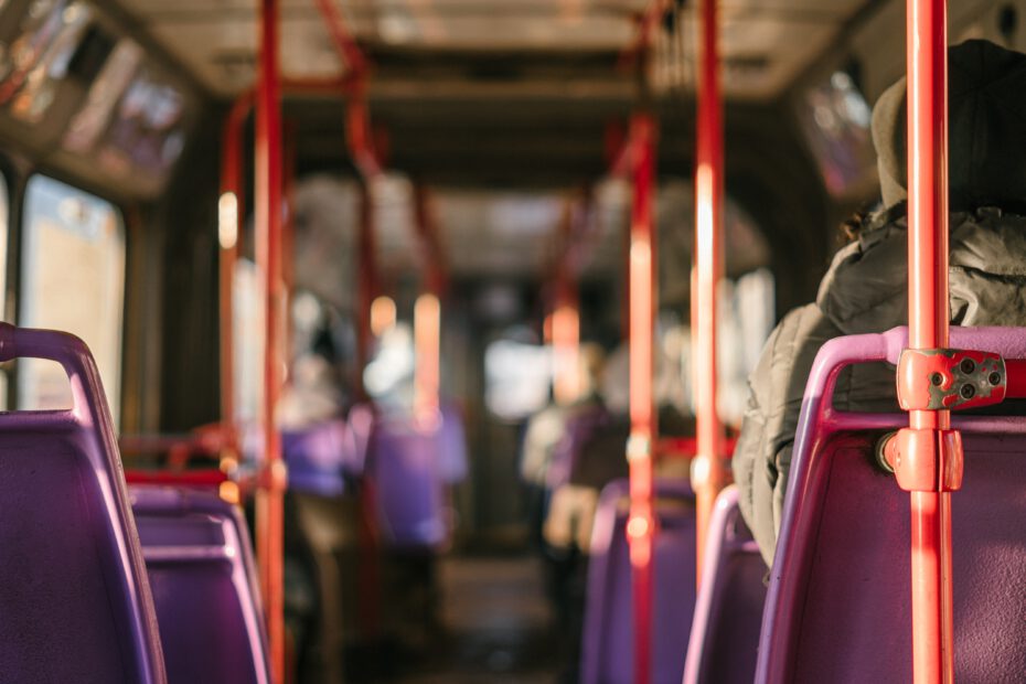 ÖPNV: Innenraum Linienbus mit roten Haltestangen und violetten Sitzen