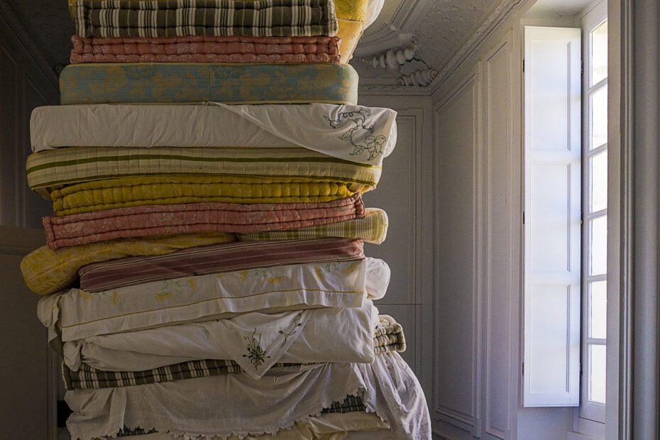 Ein Stapel gebrauchter Matratzen in einem Raum mit hoher Zimmerdecke