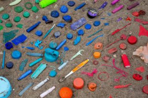 Farblich sortierter Plastikmüll om Sand – Ressource für Öl?